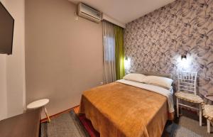 a small room with a bed and a tv at Pansion Villa Nur in Mostar