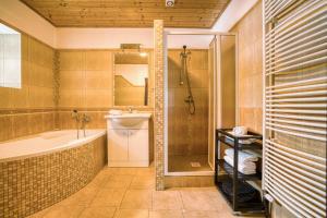 ein Bad mit einer Badewanne, einer Dusche und einem Waschbecken in der Unterkunft Apartmány Pod Šerákem in Lipová-lázně