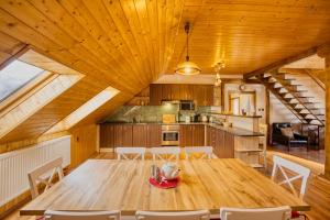 cocina y comedor con mesa de madera y sillas en Apartmány Pod Šerákem, en Lipová-lázně