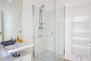 a white bathroom with a shower and a sink at Vienna Living Apartments - Ottakring in Vienna