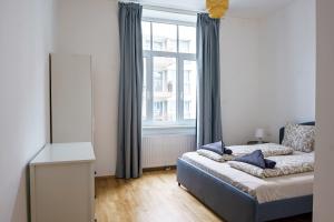 um quarto com uma cama e uma grande janela em Vienna Living Apartments - Ottakring em Viena