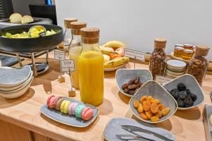- une table avec des assiettes de nourriture et une bouteille de jus d'orange dans l'établissement Hotel Elysees Opera, à Paris