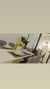 uma mesa longa com cadeiras e pratos em Orchid Guesthouse Kuantan em Kuantan