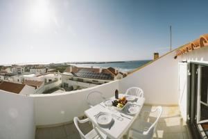 d'un balcon avec une table et des chaises donnant sur l'océan. dans l'établissement Best Houses 31 - Seashell House, à Baleal