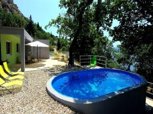 奧米什的住宿－Holiday Home Hrstic，树荫庭院里的热水浴池