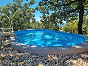 奧米什的住宿－Holiday Home Hrstic，一座带树木的庭院内的热水浴池