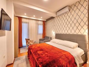 a bedroom with a bed and a chair at Pansion Villa Nur in Mostar