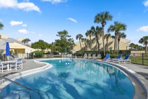 a large swimming pool with chairs and palm trees at Fairway Dream - Sawgrass 2 Bedrooms - 2 Bath Villas Sleep 6, Close To Beach in Ponte Vedra Beach