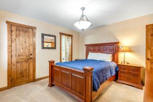 a bedroom with a wooden bed and a wooden door at Larkspur Lodge in Avon