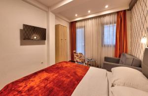 a hotel room with a large bed and a couch at Pansion Villa Nur in Mostar
