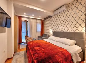 a bedroom with a bed and a dog sitting in a chair at Pansion Villa Nur in Mostar
