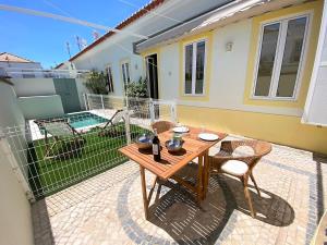 eine Terrasse mit einem Tisch und Stühlen sowie ein Haus in der Unterkunft Casa do Mar Salgado in Vila Nova De Cacela
