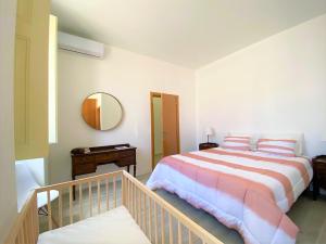 ein Schlafzimmer mit einem großen Bett und einem Spiegel in der Unterkunft Casa do Mar Salgado in Vila Nova De Cacela + 24 Fotos