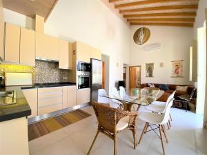 eine Küche und ein Esszimmer mit einem Glastisch und Stühlen in der Unterkunft Casa do Mar Salgado in Vila Nova De Cacela