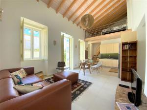 ein Wohnzimmer mit Sofa und Tisch in der Unterkunft Casa do Mar Salgado in Vila Nova De Cacela