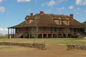 une grande maison avec un toit sur un champ dans l'établissement Mad Miner Inn Washington Camp one night free offer, à Patagonia