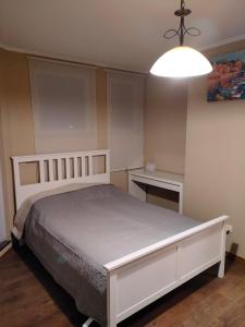 a bedroom with a white bed and a light at Mladost 1 Apartment near the metro in Sofia