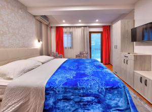 a bedroom with a large bed with a blue blanket at Pansion Villa Nur in Mostar