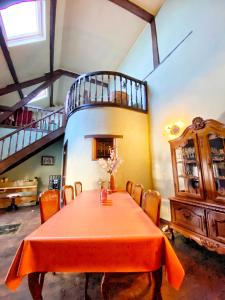 uma sala de jantar com uma mesa e uma escada em Maison Maissin em Paliseul