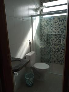 ein Bad mit einem WC, einem Waschbecken und einer Dusche in der Unterkunft Kitnetes & Aptos Praia do Capricórnio in Caraguatatuba