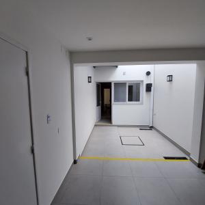 un corridoio vuoto con pareti bianche e una linea gialla sul pavimento di Departamento Salta - Calle Santiago a Salta