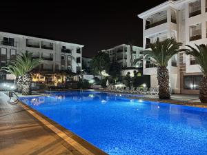 a swimming pool in front of a building at night at Lovely 2-Bed Apartment in Side - Ilica in Side
