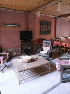 salon ze stołem, krzesłami i telewizorem w obiekcie La Elegida w mieście Tilcara