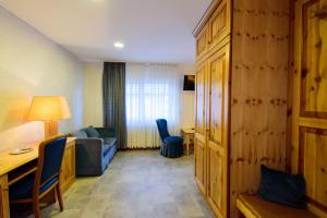 a hotel room with a couch and a table and a desk at Hotel Bohn in Metzingen