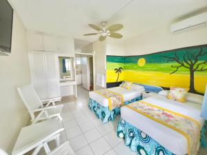 Habitación con 2 camas y una pintura en la pared. en Nautilus Ocean Suites en Bridgetown