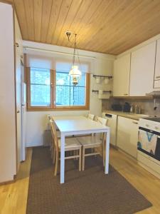 a kitchen with a white table and chairs in it at Gold Legend Paukkula #4 - Saariselkä Apartments in Saariselka