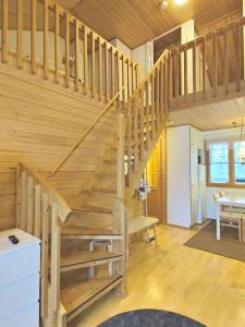 eine Holztreppe in einem Zimmer mit einem Tisch in der Unterkunft Gold Legend Paukkula #4 - Saariselkä Apartments in Saariselkä