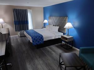 a hotel room with a bed and a blue wall at Baymont by Wyndham Adairsville in Adairsville +27 photos