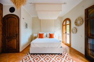 ein Schlafzimmer mit einem Bett mit orangefarbenen Kissen darauf in der Unterkunft The Lemon Garden by Elite Villas in Pontone