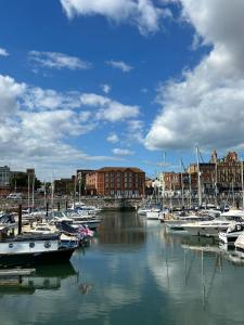 un gruppo di imbarcazioni ormeggiate in un porto con edifici di Royal View a Ramsgate