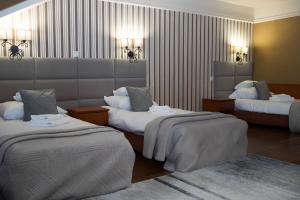 a hotel room with two beds and two lamps at Hotel Wenecki in Częstochowa