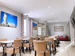 a restaurant with tables and chairs in a room at Hotel de La Comédie in Montpellier