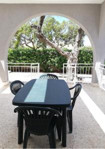 a black table with two chairs and a tree at Villa Marisole in Torre Canne