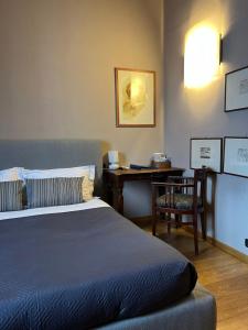 una camera con letto, scrivania e tavolo di A Casa Di Paola Suite a Ravenna