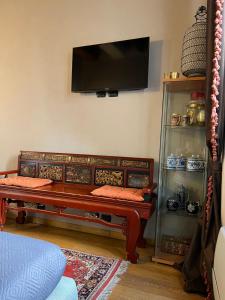 un soggiorno con panca e TV a schermo piatto di A Casa Di Paola Suite a Ravenna