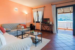 un soggiorno con un divano e una TV di [Terrace on Porto Cervo] Swimming pool & private beach a Porto Cervo