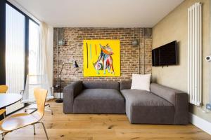 a living room with a couch and a brick wall at Cool Loft in fashionable East London in London
