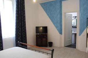 ein Schlafzimmer mit einem Bett und einem TV in einem Zimmer in der Unterkunft B&b Red House in Garlate