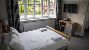 um quarto com uma cama e uma grande janela em The Star Inn em Lingfield