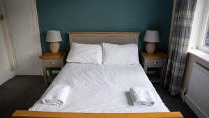 una camera con un letto con due comodini e due lampade di The Star Inn a Lingfield