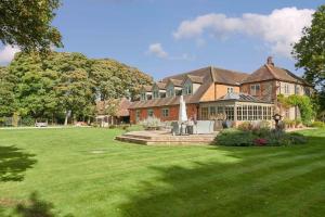 uma casa grande com um grande relvado em frente em The Whistler's Perch em Buckinghamshire