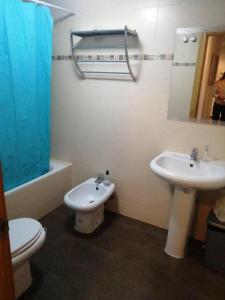 a bathroom with a toilet and a sink and a mirror at Apartamento Reina in Alcantarilla