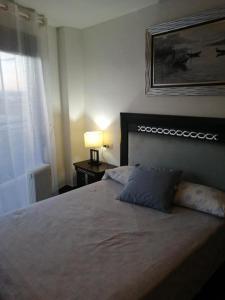 1 dormitorio con 1 cama con una foto en la pared en Apartamento Reina en Alcantarilla