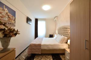 1 dormitorio con 1 cama y un jarrón de flores en Hotel Ristorante La Marina Mhotelsgroup, en San Bartolomeo al Mare