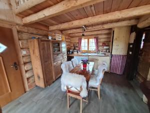 eine Küche mit einem Tisch und Stühlen in einer Hütte in der Unterkunft Naturstammhaus in Seltenheim
