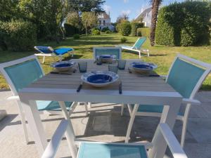 a wooden table with blue bowls and chairs at Maison Le Palais, 2 pièces, 3 personnes - FR-1-418-88 in Le Palais